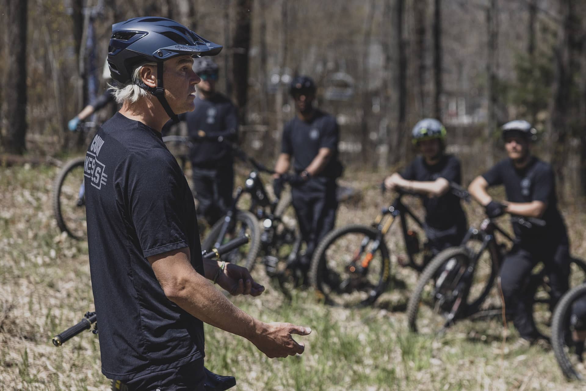 Groupe de cyclistes recevant des instructions en terrain dégagé